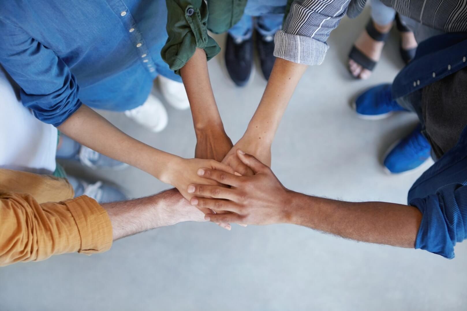 team of people putting hands together